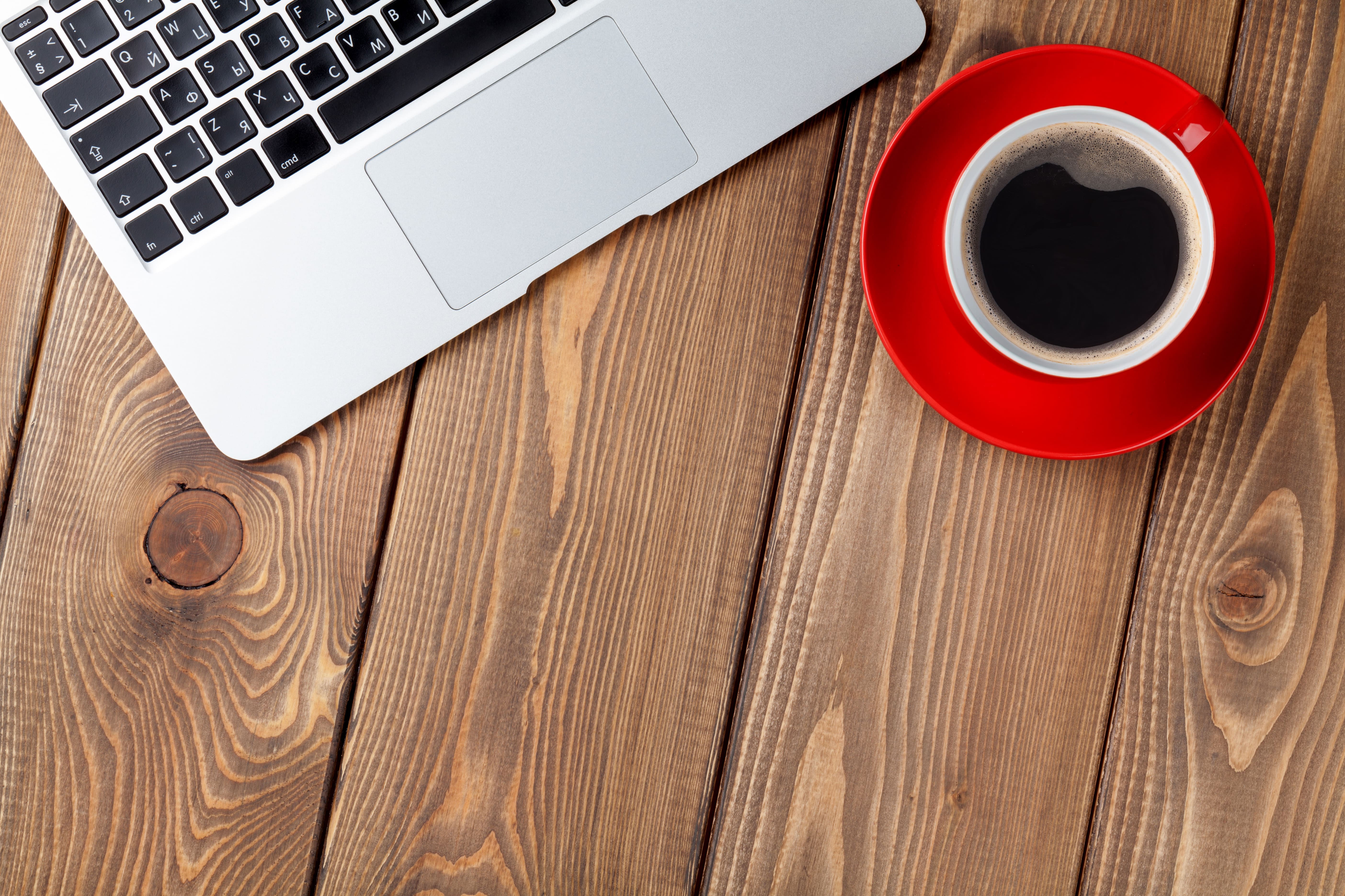 Office desk table with laptop computer and coffee cup